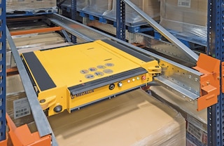 Pallet Shuttle vagoniņš pārvietojas plauktu uzglabāšanas kanālos, izmantojot atbalsta sliedes Pallet Shuttle vagoniņš pārvietojas plauktu uzglabāšanas kanālos, izmantojot atbalsta sliedes