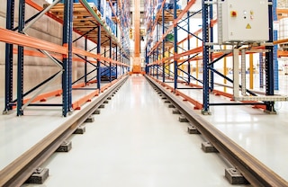 Trīsceļu automatizētais kraušanas celtnis pārvietojas gar eju pa apakšējo sliežu pāri